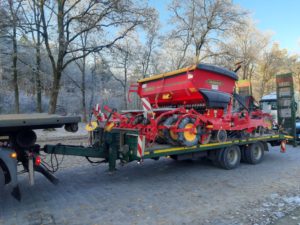 Rote Väderstad Rapid Sämaschine auf Tieflader, winterliche Landschaft mit Frostbäumen